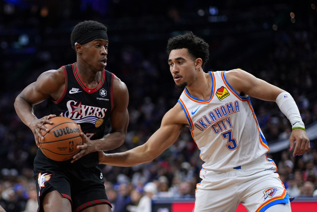 Philadelphia 76ers' Vj Edgecombe, left, tries to get past Oklahoma City Thunder's Jared McCain during the first half of an NBA basketball game Monday, March 23, 2026, in Philadelphia. (AP Photo/Matt Slocum)