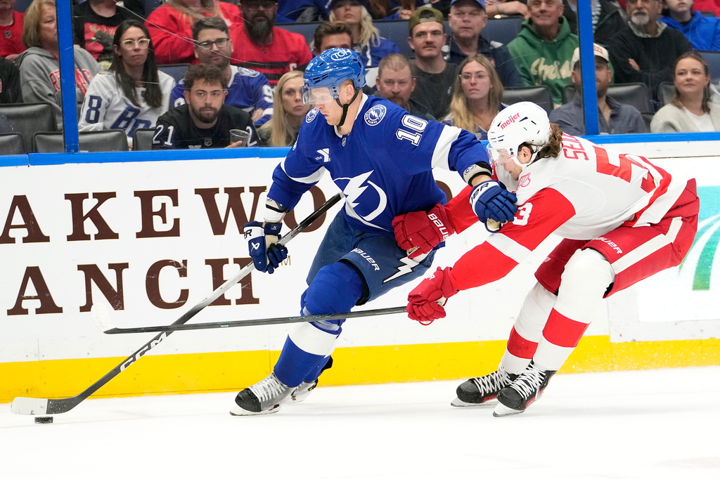 Tampa Bay Lightning right wing Corey Perry (10) holds off Detroit Red Wings defenseman Moritz Seider (53) during the second period of an NHL hockey game Thursday, March 12, 2026, at Benchmark International Arena in Tampa, Fla. (AP Photo/Chris O'Meara)