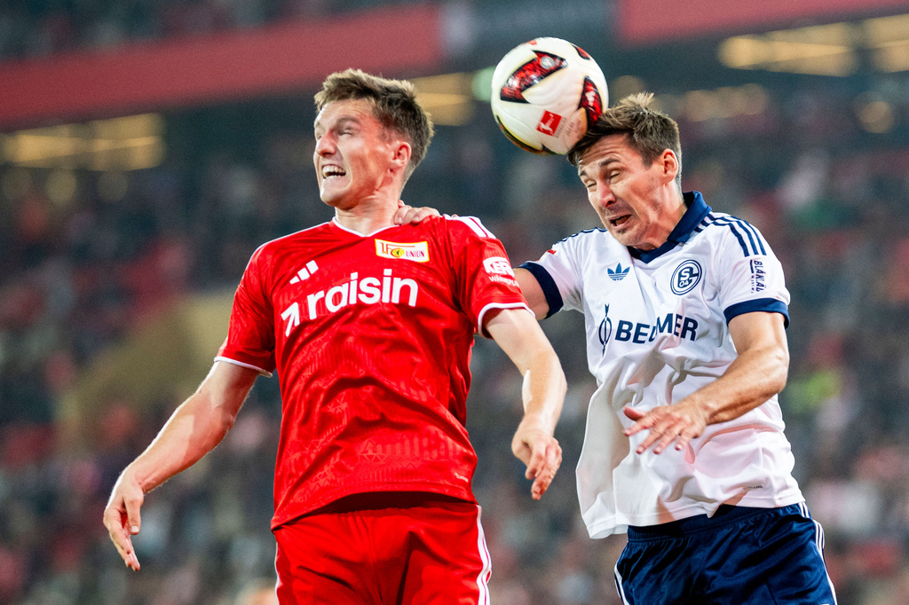 Schalke's Michel Aebischer, right, heads the ball from behind Berlin's Max Wöber during the German Bundesliga soccer match between Union Berlin and FC Schalke in Berlin, Friday, Sept. 11, 2026. (Julius Frick/dpa via AP)
