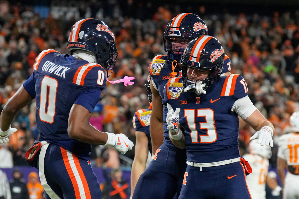 Illinois wide receiver Justin Bowick (0) celebrates his touchdown with Hudson Clement (13) and running back Kaden Feagin, center, during the first half of the Music City Bowl NCAA college football game against Tennessee, Tuesday, Dec. 30, 2025, in Nashville, Tenn. (AP Photo/George Walker IV)