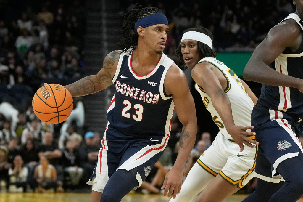 Gonzaga guard Adam Miller (23) drives to the basket against San Francisco guard Tyrone Riley IV during the first half of an NCAA college basketball game in San Francisco, Wednesday, Feb. 18, 2026. (AP Photo/Jeff Chiu)