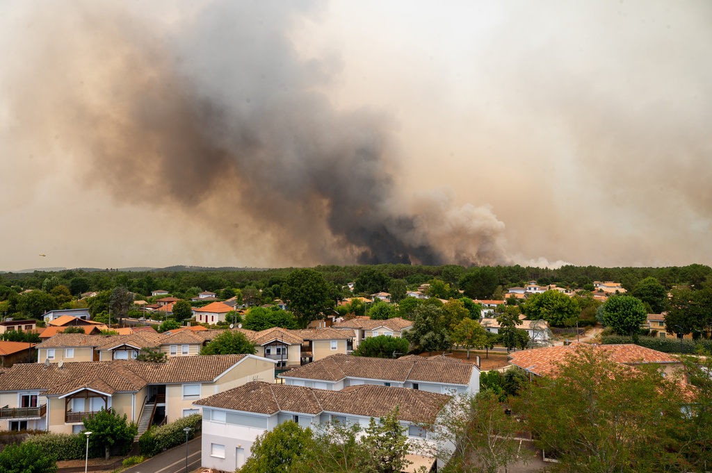 Smoke rises over wildfires in the Lège-Cap-Ferret region, western France, Thursday, July 23, 2026. (AP Photo/Caroline Blumberg)