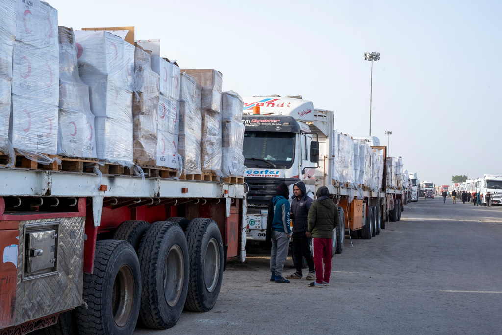 Trucks line up to enter the Egyptian gate of the Rafah crossing, heading for inspection by Israeli authorities before entering the Gaza Strip, Tuesday, Jan.27, 2026. (AP Photo/Mohamed Arafat)