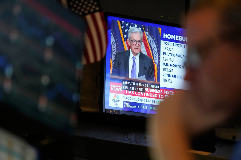 A television displays a news conference with Fed chairman Jerome Powell on the floor at the New York Stock Exchange in New York, Wednesday, Dec. 10, 2025. (AP Photo/Seth Wenig)