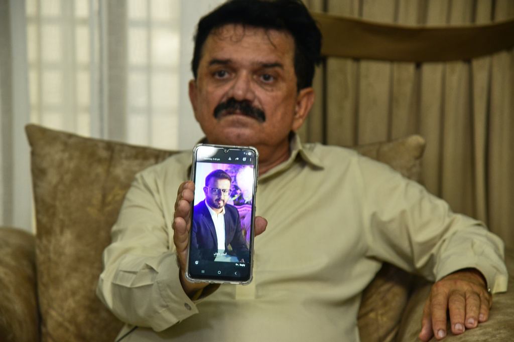 Ghulam Nabi Bahrani, father-in-law of missing cargo plane crew First Officer Faisal Jatoi, showed his picture on a mobile phone in Karachi, Pakistan, Wednesday, July 8, 2026. (AP Photo/Ali Raza)