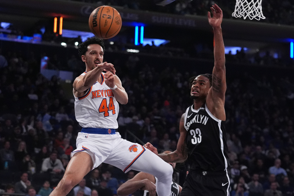 New York Knicks' Landry Shamet (44) passes away from Brooklyn Nets' Nic Claxton (33) during the first half of an NBA basketball game Wednesday, Jan. 21, 2026, in New York. (AP Photo/Frank Franklin II)
