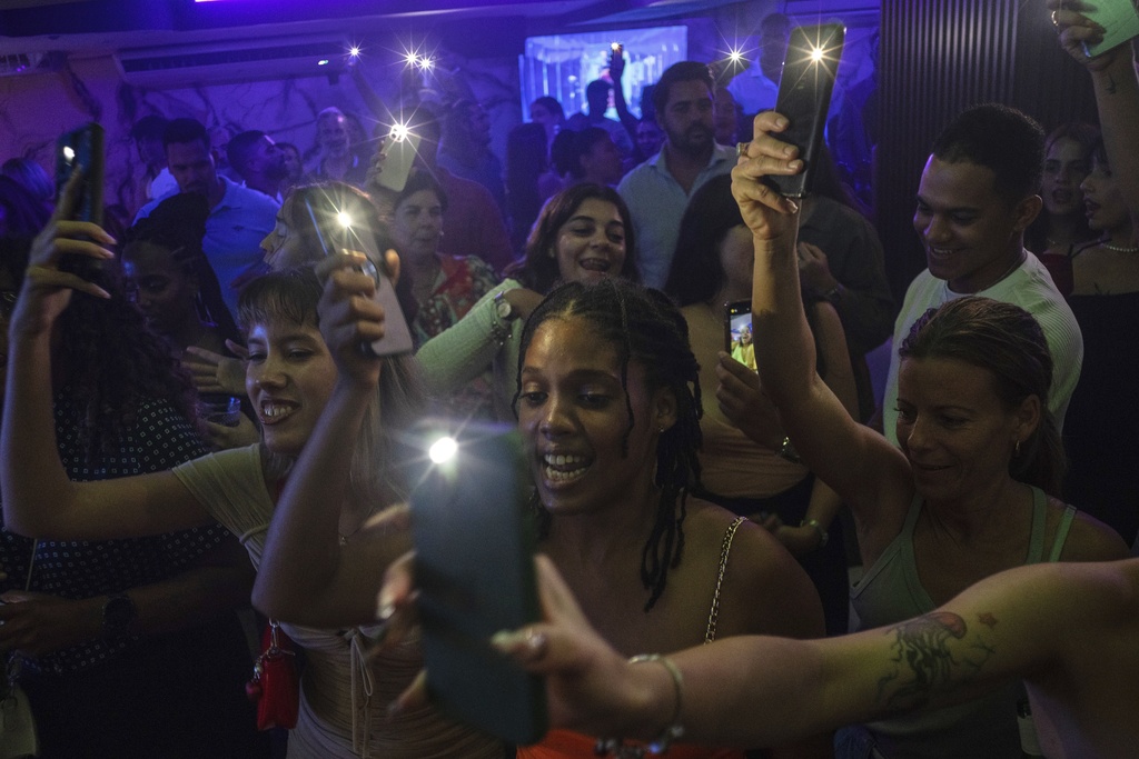 Music fans react as they watch Melanie Santiler, a 23-year-old pop singer and songwriter who has gained a following among young people, performs at the Shangri La in Havana, Thursday, Aug. 28, 2025. (AP Photo/Ramon Espinosa)