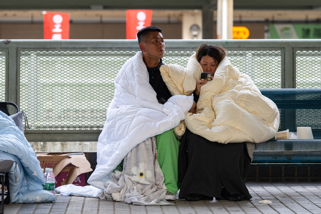 Residents rest at the fire scene at Wang Fuk Court, a residential estate in the Tai Po district of Hong Kong's New Territories, Thursday, Nov. 27 2025. (AP Photo/Chan Long Hei)