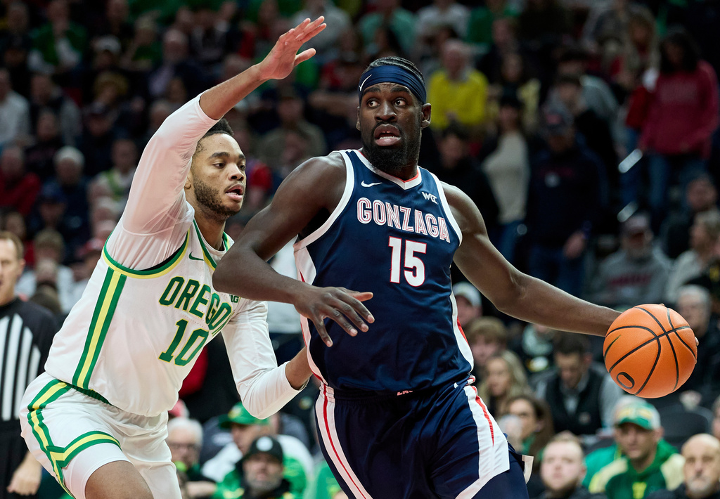 Gonzaga forward Graham Ike, right, dribbles past Oregon forward Kwame Evans Jr. during the first half of an NCAA college basketball game in Portland, Ore., Sunday, Dec. 21, 2025. (AP Photo/Craig Mitchelldyer)