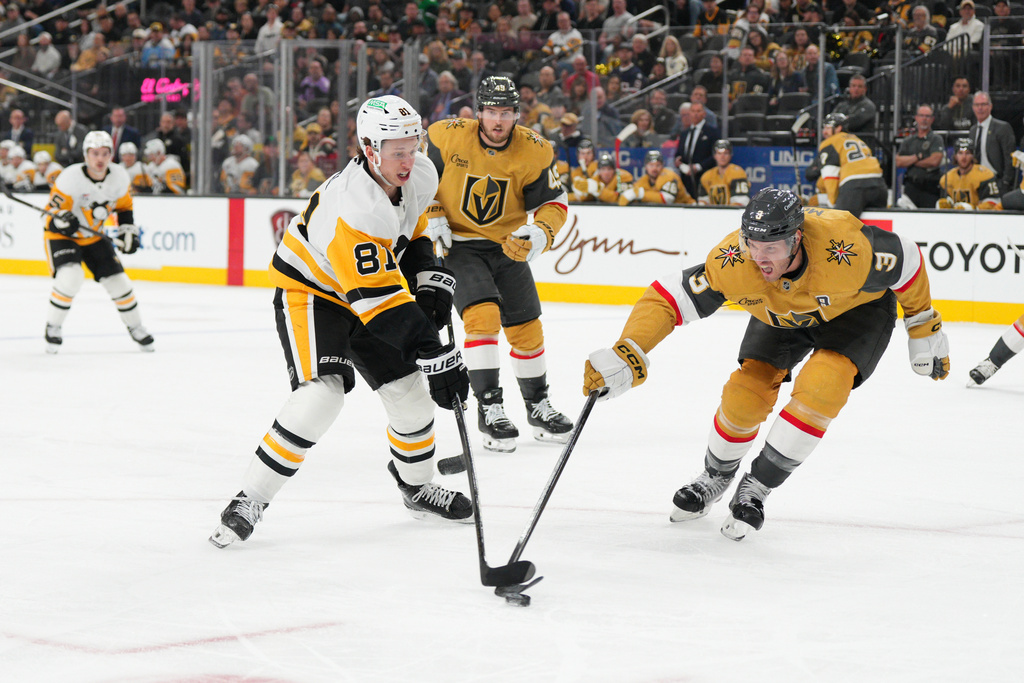 Pittsburgh Penguins center Ben Kindel (81) skates with the puck against Vegas Golden Knights defenseman Brayden McNabb during the first period of an NHL hockey game Thursday, March 12, 2026, in Las Vegas. (AP Photo/Candice Ward)