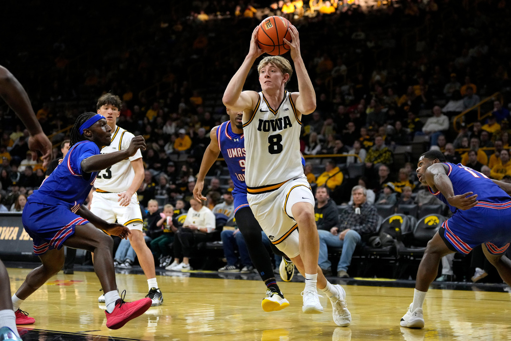 Iowa forward Cooper Koch (8) drives to the basket past UMass-Lowell guard Darrel Yepdo, left, during the first half of an NCAA college basketball game, Monday, Dec. 29, 2025, in Iowa City, Iowa. (AP Photo/Charlie Neibergall)