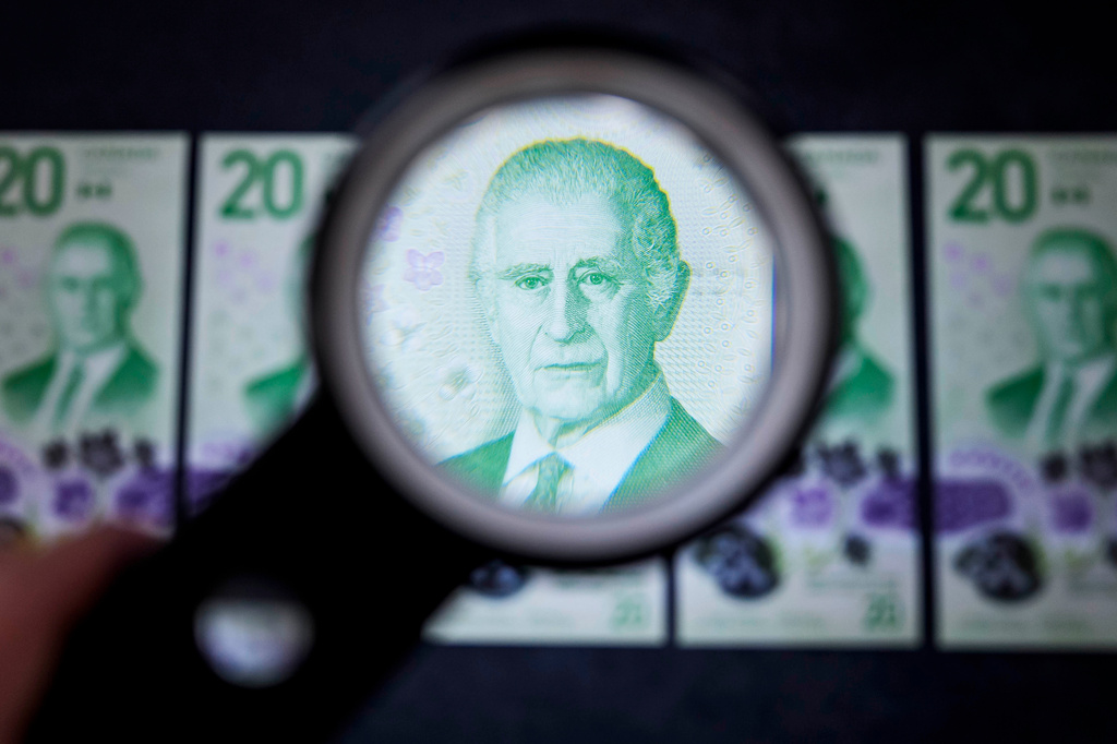 The portrait of King Charles III on the new Canadian $20 note is seen under a magnifying glass at its unveiling event in Ottawa, on Thursday, Sept. 3, 2026. (Justin Tang/The Canadian Press via AP)