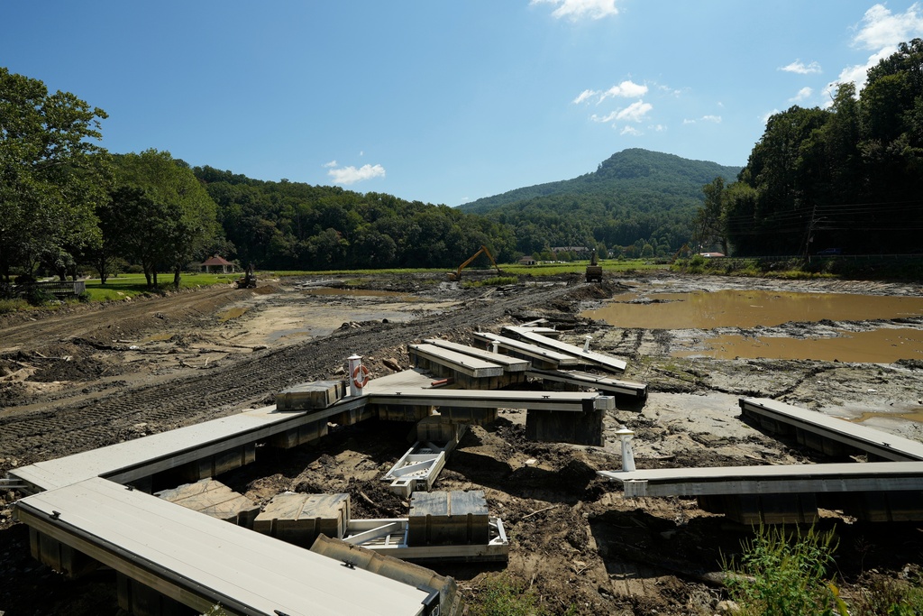 Workers cleanup debris and mud at Lake Lure, Wednesday, Sept. 17, 2025, near Chimney Rock, N.C. (AP Photo/Chris Carlson)