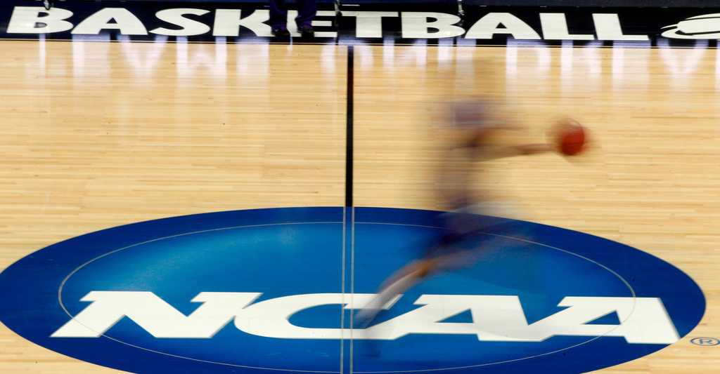 FILE - In this March 14, 2012, file photo, a player runs across the NCAA logo during practice in Pittsburgh before an NCAA tournament college basketball game. (AP Photo/Keith Srakocic, File)