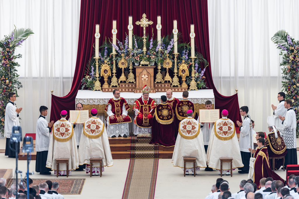 Alfonso de Galarreta from Spain, Bishop of the Society of Saint Pius X, center, gives episcopal consecration four new bishops, back to camera, during a Mass in a tent set up outside the Society of St. Pius X seminary, in Econe, Switzerland, Wednesday, July 1, 2026. (Cyril Zingaro/Keystone via AP)