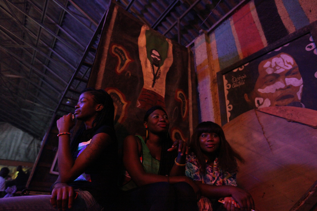 FILE - Women sit under portraits of Fela Anikulapo-Kuti at the New Afrika Shrine in Lagos, Nigeria, on Sunday, Oct. 21, 2012. (AP Photo/Jon Gambrell, File)