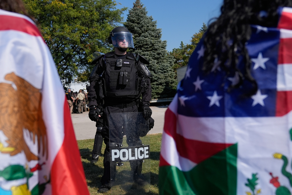Law enforcement hold back protesters near an Immigration and Customs Enforcement facility in Broadview, Ill., Friday, Oct. 3, 2025. (AP Photo/Erin Hooley)