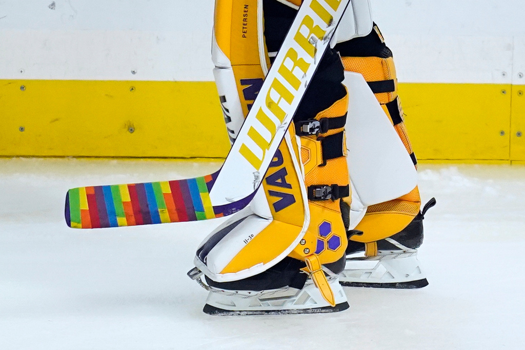FILE - Los Angeles Kings goaltender Calvin Petersen (40) holds a stick wrapped in rainbow tape for Pride night while warming up before an NHL hockey game April 26, 2021, in Los Angeles. (AP Photo/Ashley Landis, File)