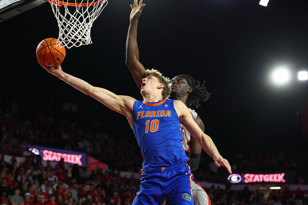 Florida forward Thomas Haugh (10) shoots against Georgia center Somto Cyril, right, during the first half of an NCAA college basketball game, Wednesday, Feb. 11, 2026, in Athens, Ga. (AP Photo/Colin Hubbard)