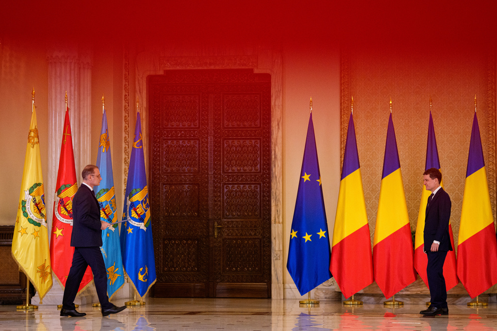 Romanian Prime Minister Luca Niculescu, left, prepares to hand his oath to Romanian President Nicusor Dan during a swearing in ceremony for the new government at the Cotroceni Presidential Palace, in Bucharest, Romania, Tuesday, Oct. 20, 2026. (AP Photo/Andreea Alexandru)