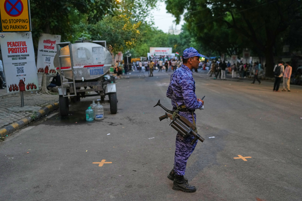 An Indian paramilitary soldier walks past a few remaining Cockroach Janta Party protesters after authorities move to disperse a demonstration demanding the resignation of Education Minister Dharmendra Pradhan over alleged examination irregularities and repeated paper leaks in New Delhi, India, Saturday, June 20, 2026. (AP Photo/Manish Swarup)