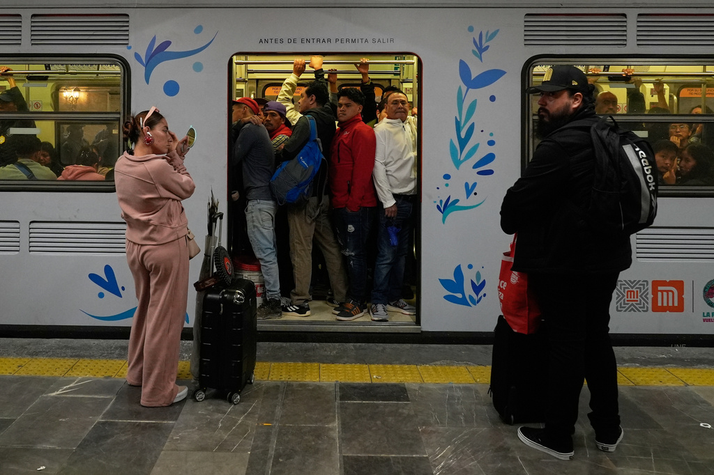 A woman puts on makeup at the subway in Mexico City, Tuesday, June 9, 2026. (AP Photo/Marco Ugarte)