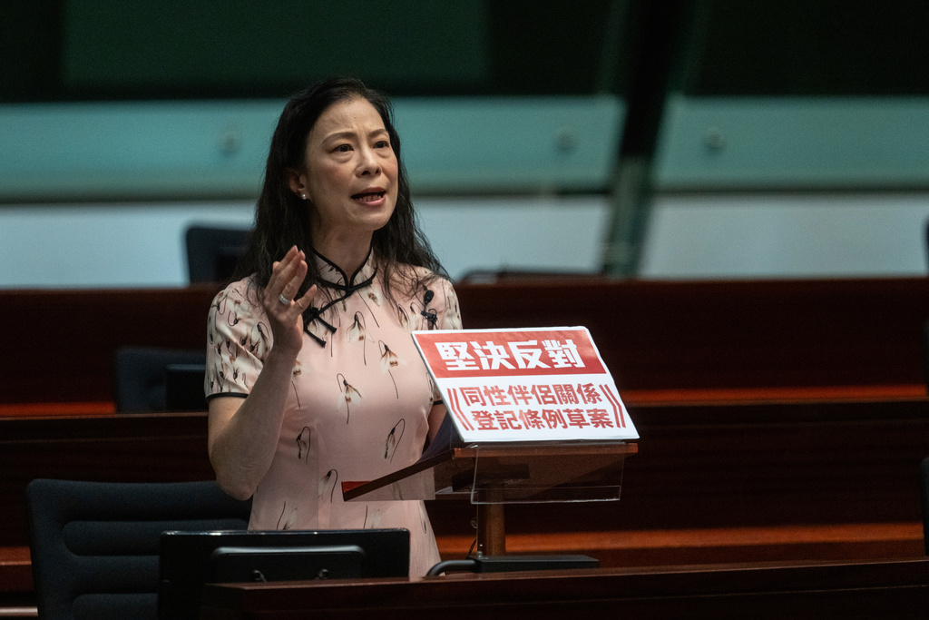 Lawmaker Maggie Chan gives a speech on a government bill that proposed to grant recognition to same-sex partnerships in Hong Kong, Wednesday, Sept. 10, 2025. A sign reads "Resolutely oppose Registration of Same-Sex Partnerships Bill." (AP Photo/Chan Long Hei)