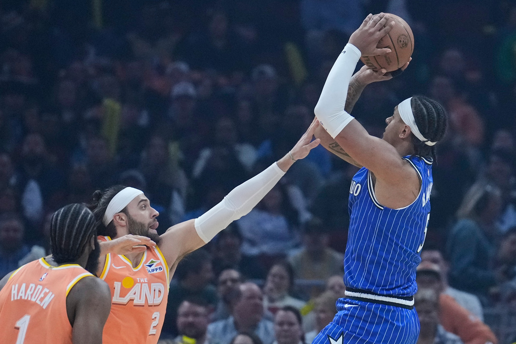 Orlando Magic forward Paolo Banchero, right, shoots over Cleveland Cavaliers guard Max Strus (2) in the first half of an NBA basketball game in Cleveland, Tuesday, March 24, 2026. (AP Photo/Sue Ogrocki)