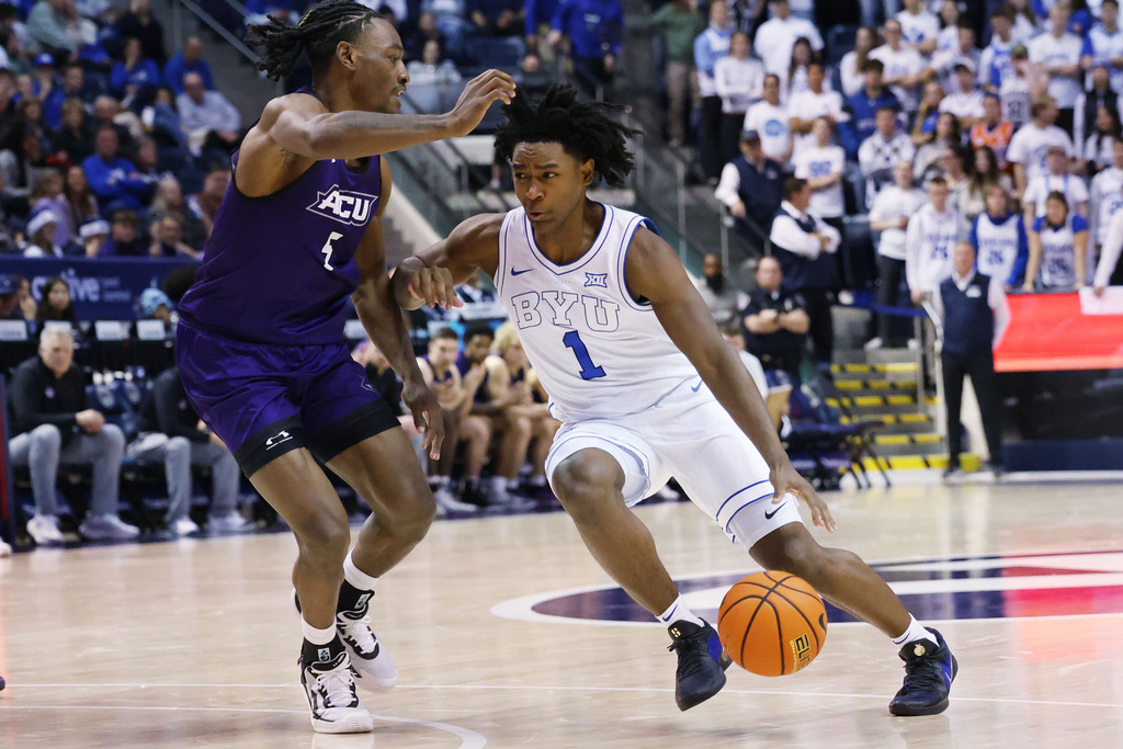 BYU guard Robert Wright III drives on Abilene Christian guard Cbo Newton during the second half of an NCAA college basketball game Friday, Dec. 19, 2025, in Provo, Utah. (AP Photo/Jeffrey D. Allred)