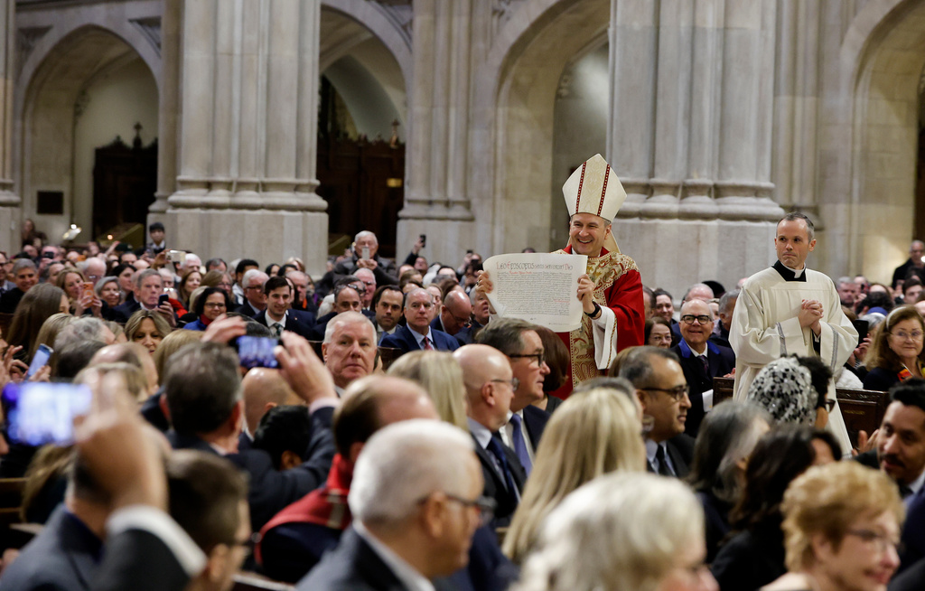 Archbishop Ronald Hicks shows the apostolic letter to the congregation after receiving it from Cardinal Christophe Pierre, apostolic nuncio to the United States, during the Mass of Installation at St. Patrick's Cathedral, Friday, Feb. 6, 2026, in New York. (AP Photo/Stefan Jeremiah)