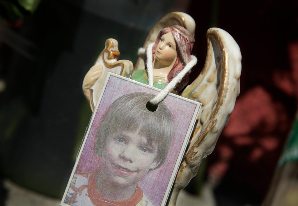 FILE - A photograph of Etan Patz hangs on an angel figurine, as part of a makeshift memorial in New York, May 28, 2012. (AP Photo/Mark Lennihan, File)