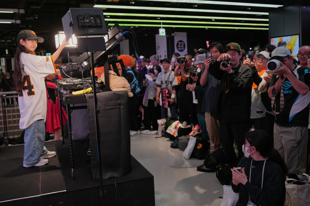 Nine-year-old DJ Rinoka, left, performs at Tokyo Dome before a Yomiuri Giants baseball game on May 24, 2026, in Tokyo. (AP Photo/Eugene Hoshiko)