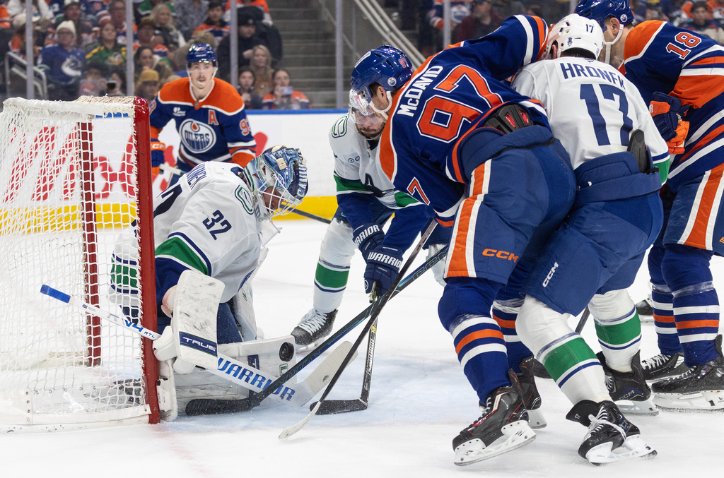 Vancouver Canucks goalie Kevin Lankinen (32) makes a save against Edmonton Oilers' Connor McDavid (97) during second-period NHL hockey game action in Edmonton, Alberta, Thursday April 16, 2026. (Jason Franson/The Canadian Press via AP)