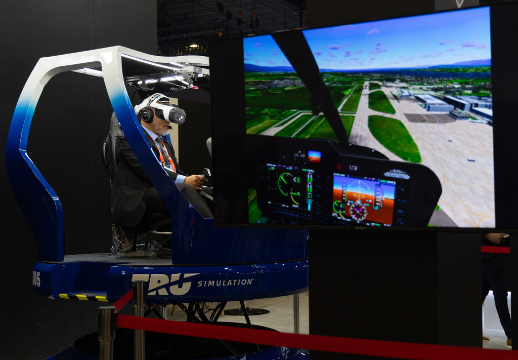 A man tries out a helicopter simulation during the Singapore Air Show on Tuesday, Feb. 3, 2026. (AP Photo/Anton L. Delgado)