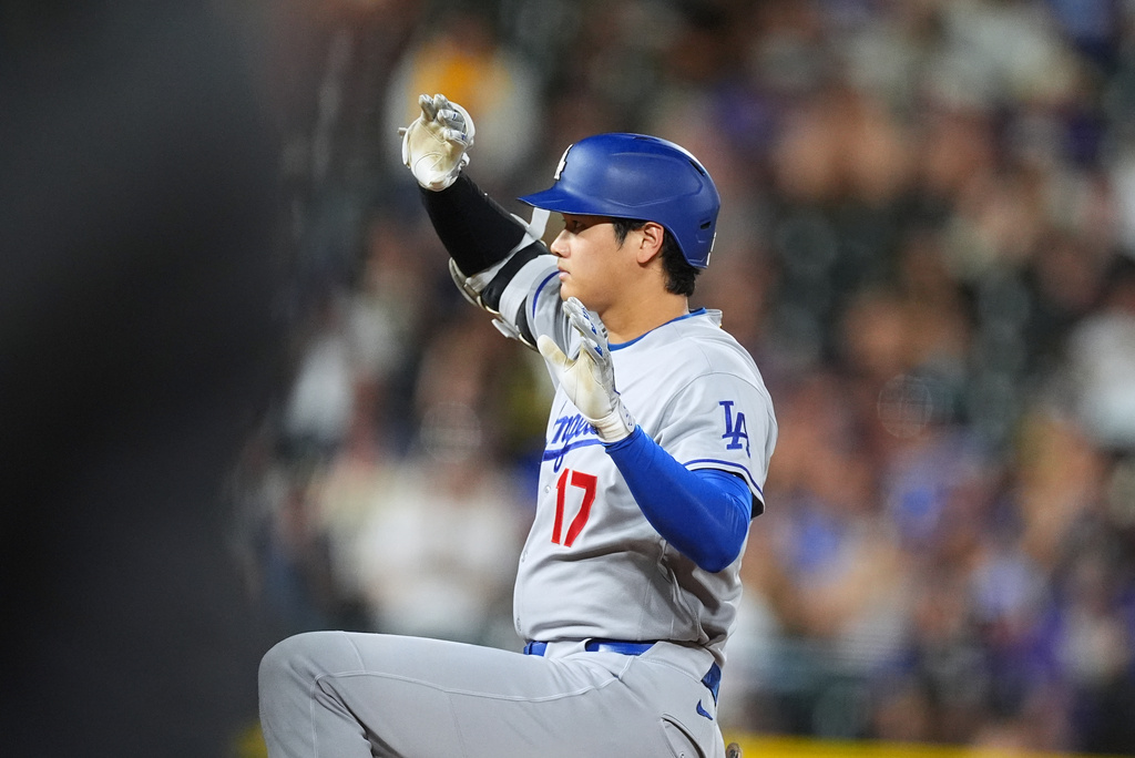 Los Angeles Dodgers' Shohei Ohtani gestures to the dugout after reaching second base on a double off Colorado Rockies relief pitcher TJ Shook in the eighth inning of a baseball game Monday, Aug. 17, 2026, in Denver. (AP Photo/David Zalubowski)