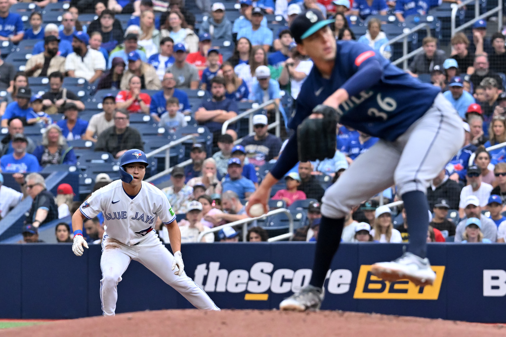 Toronto Blue Jays' Brett Bateman, left, leads off first base against Seattle Mariners starting pitcher Logan Gilbert (36) during the first inning of a baseball game in Toronto, Sunday, Aug. 30, 2026. (Jon Blacker/The Canadian Press via AP)