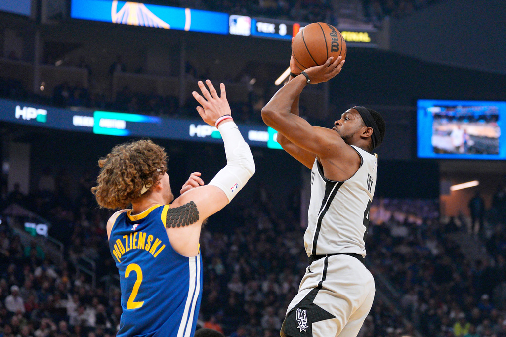 San Antonio Spurs guard De'aaron Fox (4) shoots over Golden State Warriors guard Brandin Podziemski (2) during the first half of an NBA basketball game in San Francisco, Wednesday, April 1, 2026. (AP Photo/Tony Avelar)