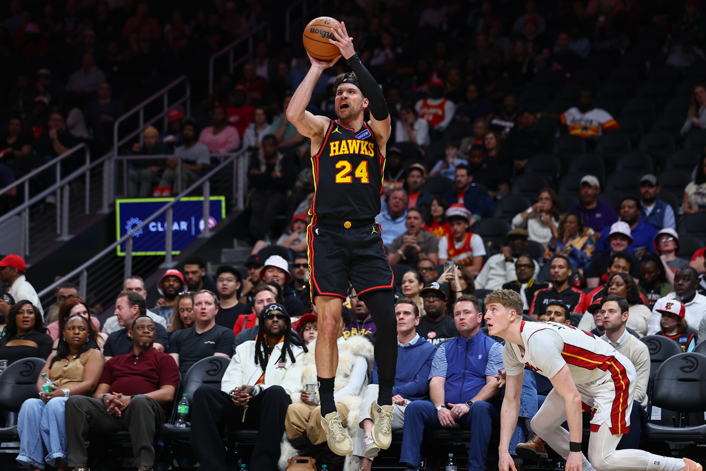 Atlanta Hawks forward Corey Kispert (24) shoots against Miami Heat guard Kasparas Jakucionis, right, during the first half of an NBA basketball game, Friday, Feb. 20, 2026, in Atlanta. (AP Photo/Colin Hubbard)