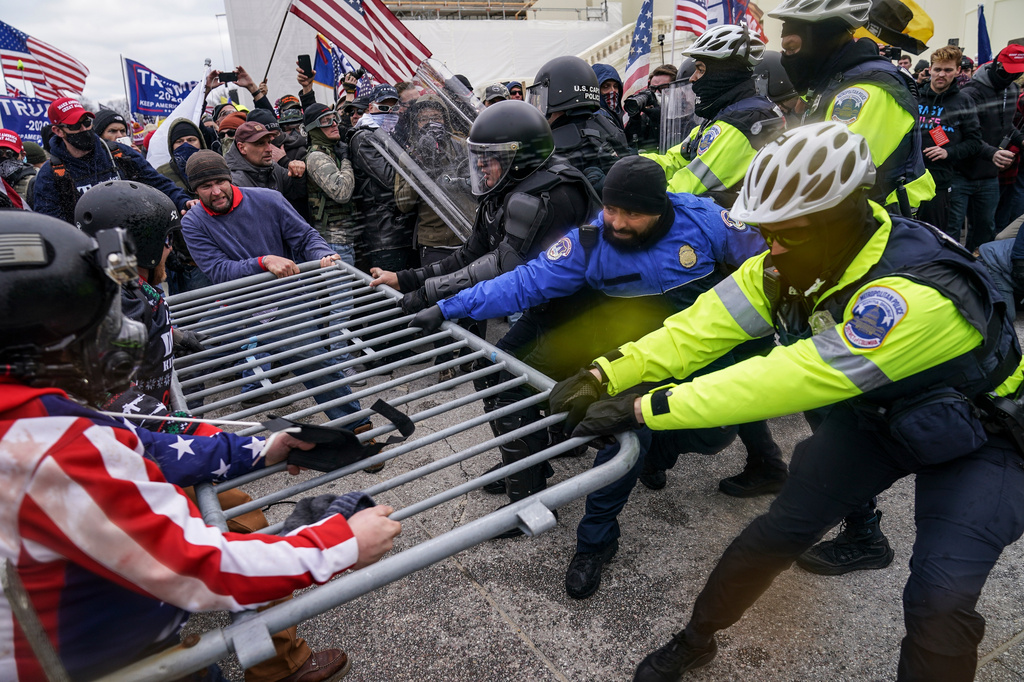 FILE - Trump supporters try to break through a police barrier, Jan. 6, 2021, at the Capitol in Washington. (AP Photo/John Minchillo, File)