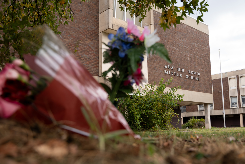 Flowers are left at a memorial for Kada Scott near the abandoned Ada H. H. Lewis Middle School Monday, Oct. 20, 2025, in Philadelphia. (AP Photo/Mingson Lau)