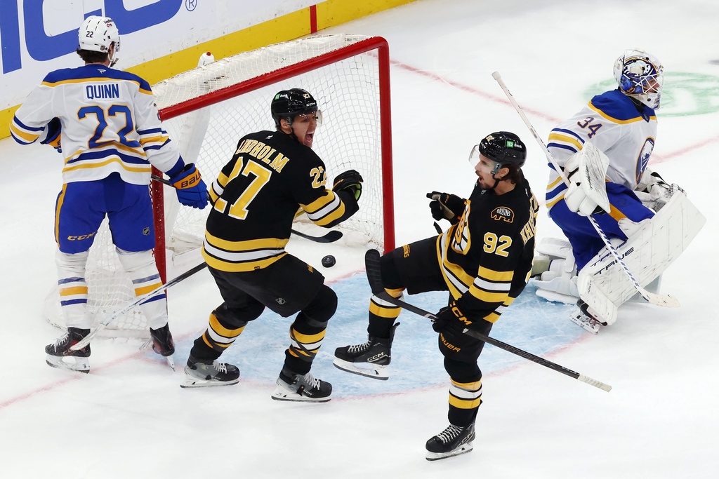 Boston Bruins' Marat Khusnutdinov (92) celebrates his goal on Buffalo Sabres' Alex Lyon with teammate Hampus Lindholm (27) in overtime during an NHL hockey game, Thursday, Oct. 30, 2025, in Boston. (AP Photo/Michael Dwyer)