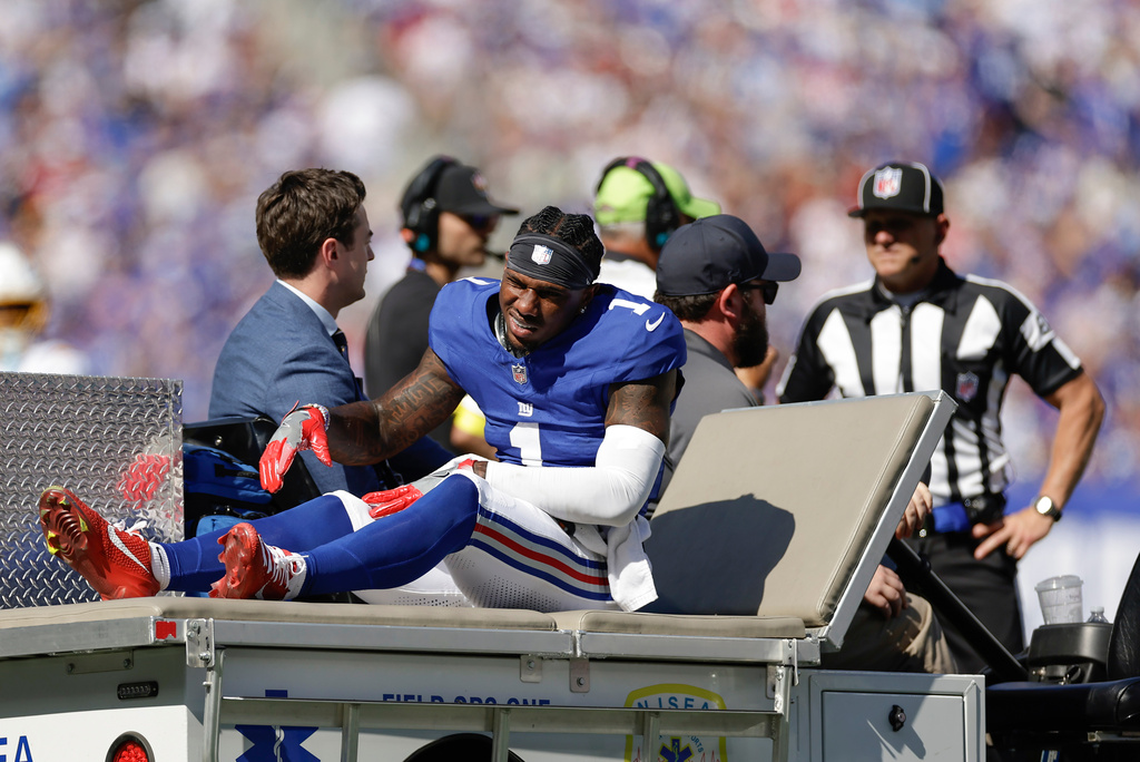 New York Giants wide receiver Malik Nabers (1) is driven off the field after an injury during the second quarter of an NFL football game against the Los Angeles Chargers, Sunday, Sept. 28, 2025, in East Rutherford, N.J. (AP Photo/Adam Hunger)