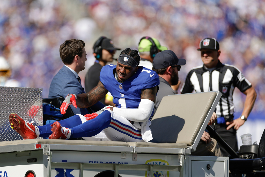 New York Giants wide receiver Malik Nabers (1) is driven off the field after an injury during the second quarter of an NFL football game against the Los Angeles Chargers, Sunday, Sept. 28, 2025, in East Rutherford, N.J. (AP Photo/Adam Hunger)