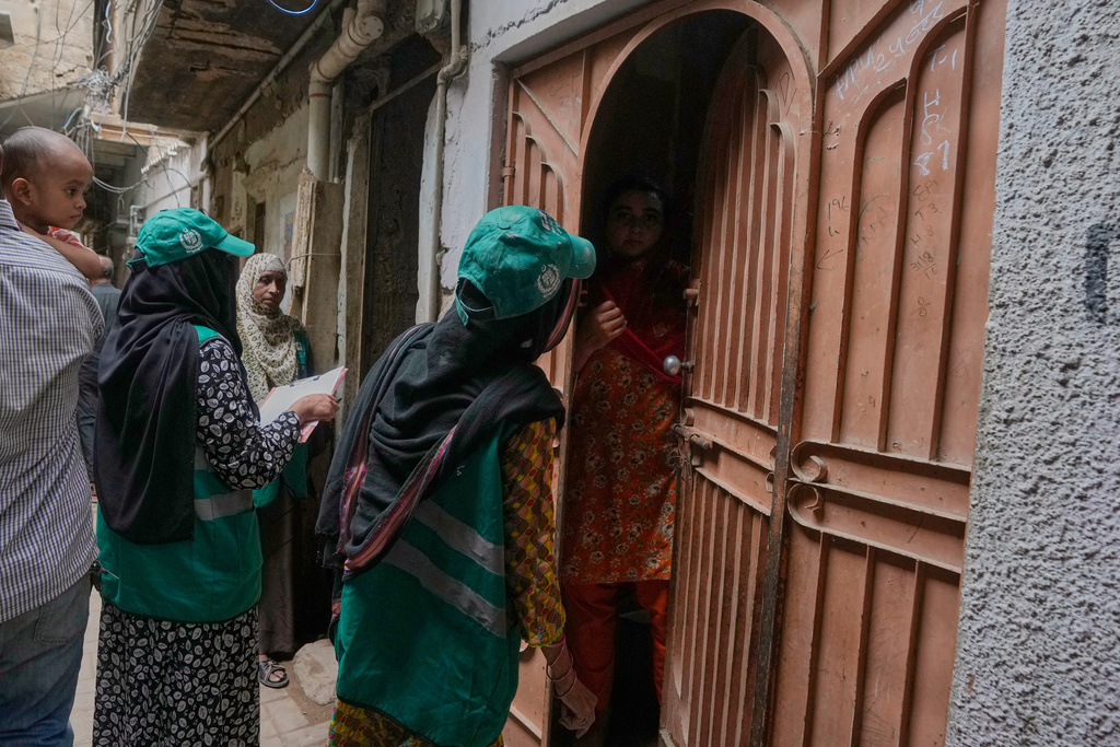 A heath worker talks with a woman during a human papillomavirus (HPV) vaccination campaign aiming to protect girls from cervical cancer, at a neighbourhood of Karachi, Pakistan, Wednesday, Sept. 24, 2025. (AP Photo/Fareed Khan)