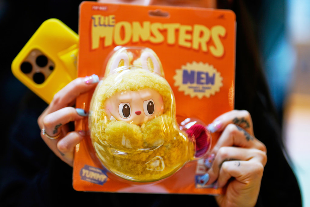 FILE - A customer shows a new Labubu doll to media during the opening of Germany
