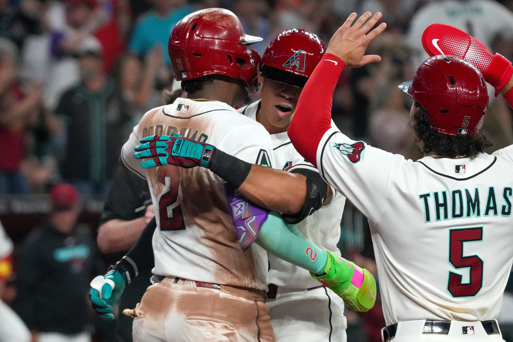 Arizona Diamondbacks' Jose Fernandez, middle, celebrates his second home run with teammates Geraldo Perdomo, left, Alek Thomas, right, during the eighth inning of a baseball game against the Detroit Tigers Tuesday, March 31, 2026, in Phoenix. (AP Photo/Darryl Webb)