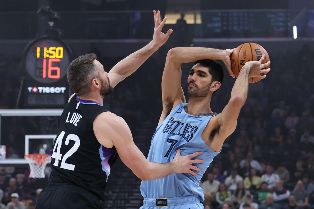Memphis Grizzlies forward Santi Aldama (7) looks for the play as Utah Jazz forward Kevin Love (42) defends during the first half of an NBA basketball game, Tuesday, Dec. 23, 2025, in Salt Lake City. (AP Photo/Rob Gray)