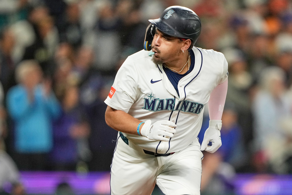 Seattle Mariners' Josh Naylor reacts after hitting a three-run double that scored Luke Raley, J.P. Crawford, and Julio Rodriguez during the eighth inning of a baseball game against the Colorado Rockies, Tuesday, Sept. 23, 2025, in Seattle. (AP Photo/Ryan Sun)