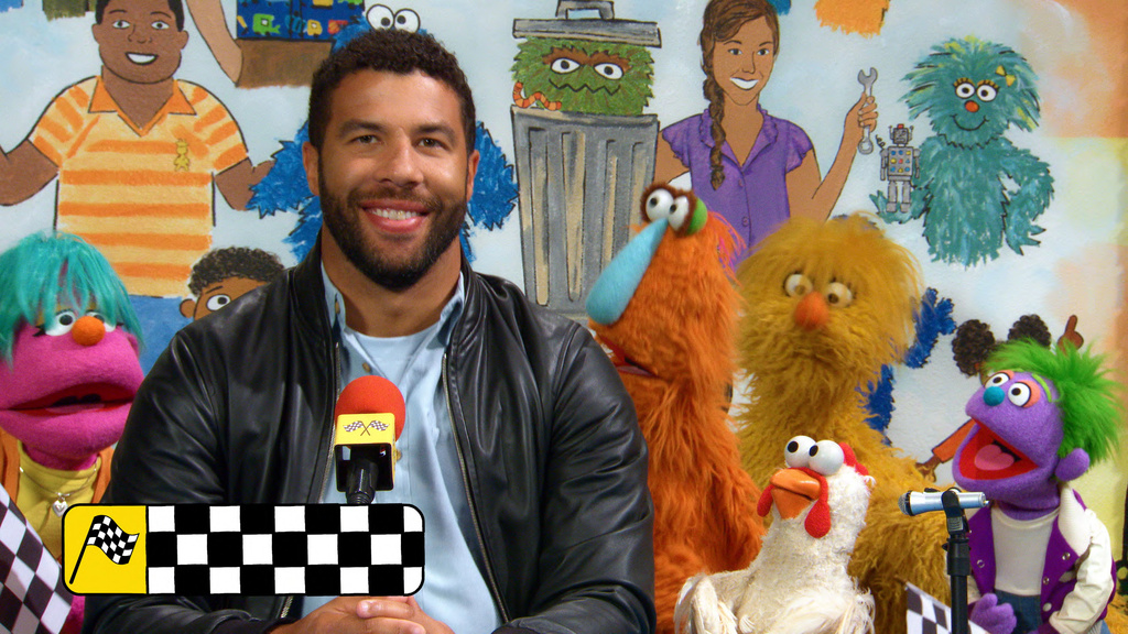 This image released by Sesame Workshop shows Bubba Wallace with various muppet characters on the set of "Sesame Street." (Sesame Workshop/Netflix via AP)