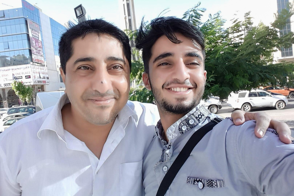 In this July 11, 2016, photo provided by Khaled al-Yemeni, Ahmed al-Yamani, left, smiles for a photo with his son, Khaled al-Yemeni. (Khaled al-Yemeni via AP)